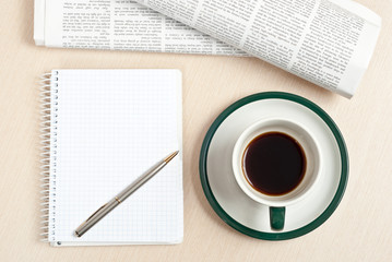 Coffee, notepad, pen and newspaper
