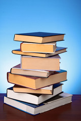 Books pile on the table and yellow background