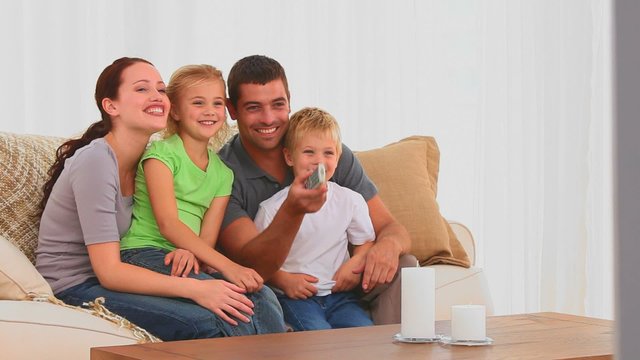 Family laughing in front of tv