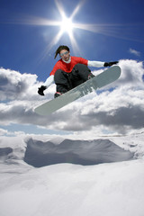 Fototapeta na wymiar Snowboarder jumping against blue sky