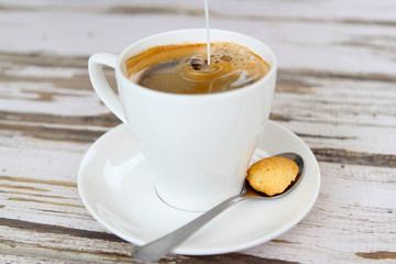 Milk pouring into fresh coffee