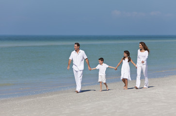 Fototapeta na wymiar Mother, Father & Children Family Walking Holding Hands On Beach