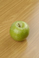 Manzana verde sobre fondo de madera