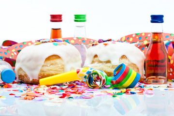 Berliner mit Zuckerguss, Likörflaschen und Tröten auf Konfetti