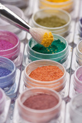 cosmetic brush pigment above containers of pigments