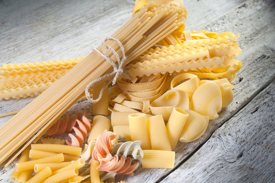raw pasta on wood background- pasta cruda su legno