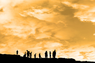 Fototapeta premium silhouette of people on peak of the cliff edge