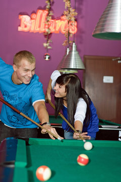 Concentrated young people playing snooker