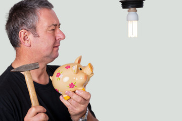 Ratloser Mann mit Sparschwein vor Lampe 307