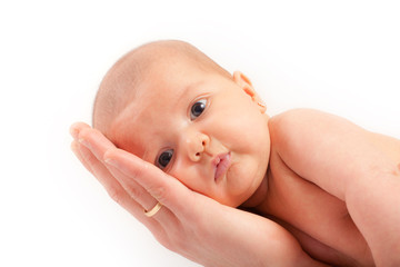 Adorable baby girl on father's hand, looking to the camera