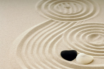 Steine als Herz im Sand mit Spuren