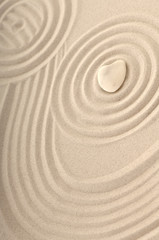 Fototapeta na wymiar Kamień jako białe serca w piasek ze śladami