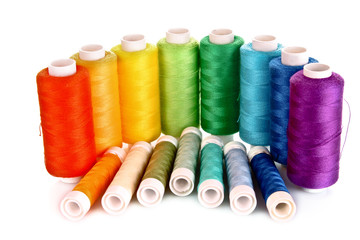 Semicircle of many-coloured bobbins of thread isolated on white