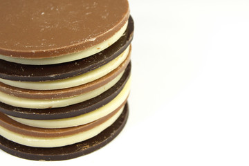 Empilement de palets de chocolat noir, blanc, au lait, détourés