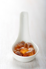 Candy sugar brown in a white spoon