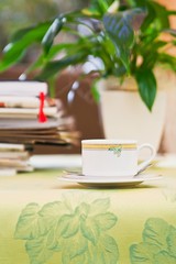 cup on a table with papers and newspapers