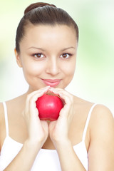 girl holding a red apple on green background