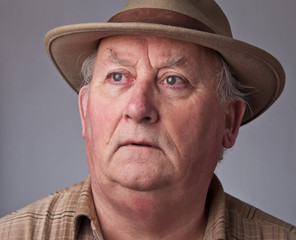 close up senior male wearing a hat