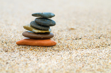 Fototapeta na wymiar Stack of beach stones on sand. Harmony, life, balance