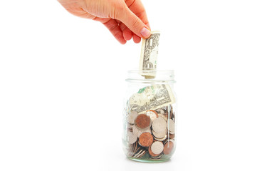 hand putting a dollar in a coin jar