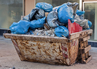 Baucontainer mit Müllsäcken und Schutt