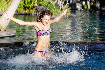 Fototapeta premium young happy woman having fun in pool