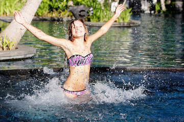 young happy woman having fun in pool