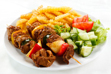 Grilled meat, French fries and vegetables
