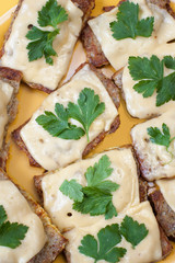 pieces of bread with melted cheese and green parsley