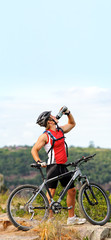 Plakat Man drinks on mountain with bicycle