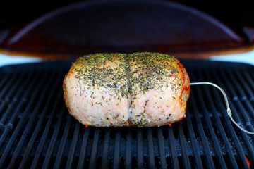 Pork meat roast roasting on the grill BBQ with thermometer
