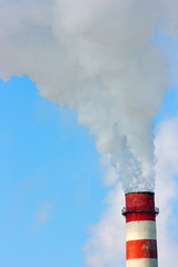 Smoking stack of the thermal power station against a blue sky