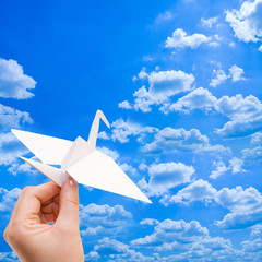 Paper crane against the blue sky