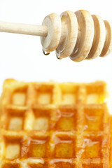 delicious Belgian waffles and stick to honey isolated on white