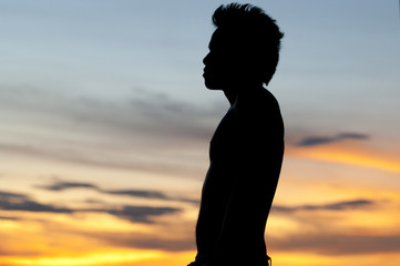 silhouetted man with sunset behind