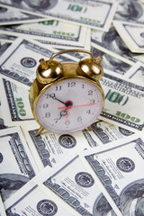 Alarm clock on a stack of dollars