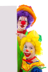 Two girl clowns holding empty text board over white background