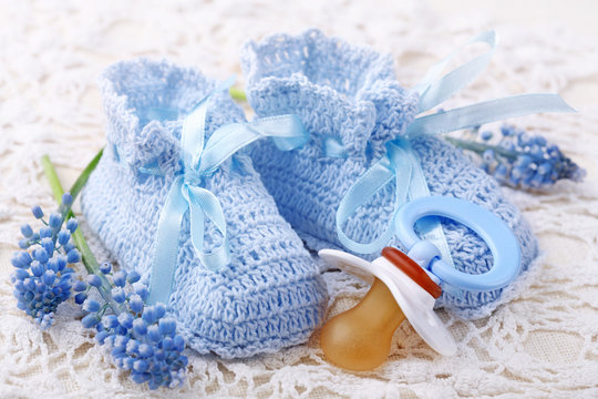 Handmade blue baby booties with dummy and flowers