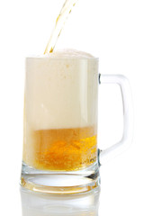 Beer flows from a bottle in a glass.