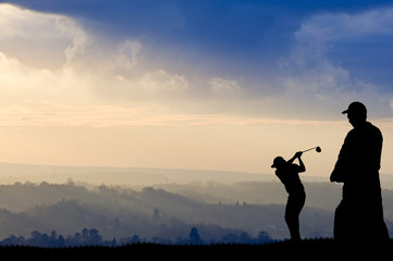 Golfer silhouette against stunning sunset sky