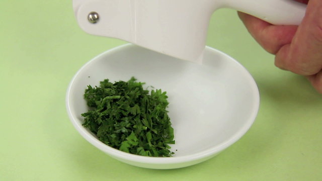 Preparing garlic butter by mixing herbs and garlic with butter