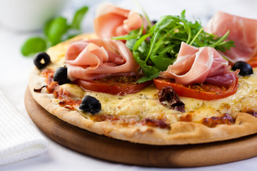 Pizza with prosciutto,tomatoes and rocket