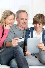 Fototapeta na wymiar Ojciec i dzieci robi zakupy online w domu