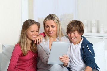 Family having fun at home using electronic tablet