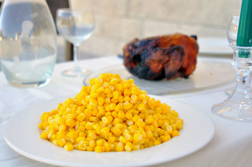 Dinner table set up, on a white tablecloth. Horizontal view.