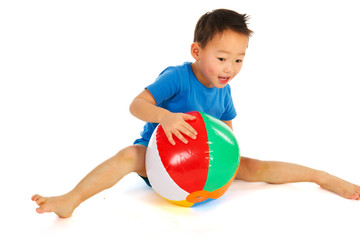 Fototapeta na wymiar Chinese boy playing with beach ball