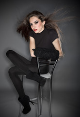 Fototapeta na wymiar Young beautiful woman in black combi dress and velvet gloves hol