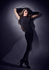Young slim glamour lady with long hairs dressed in black combi d