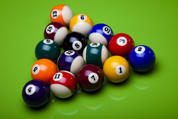Billiard balls, cue on green table