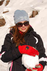 Girl with red gloves and a big snowball